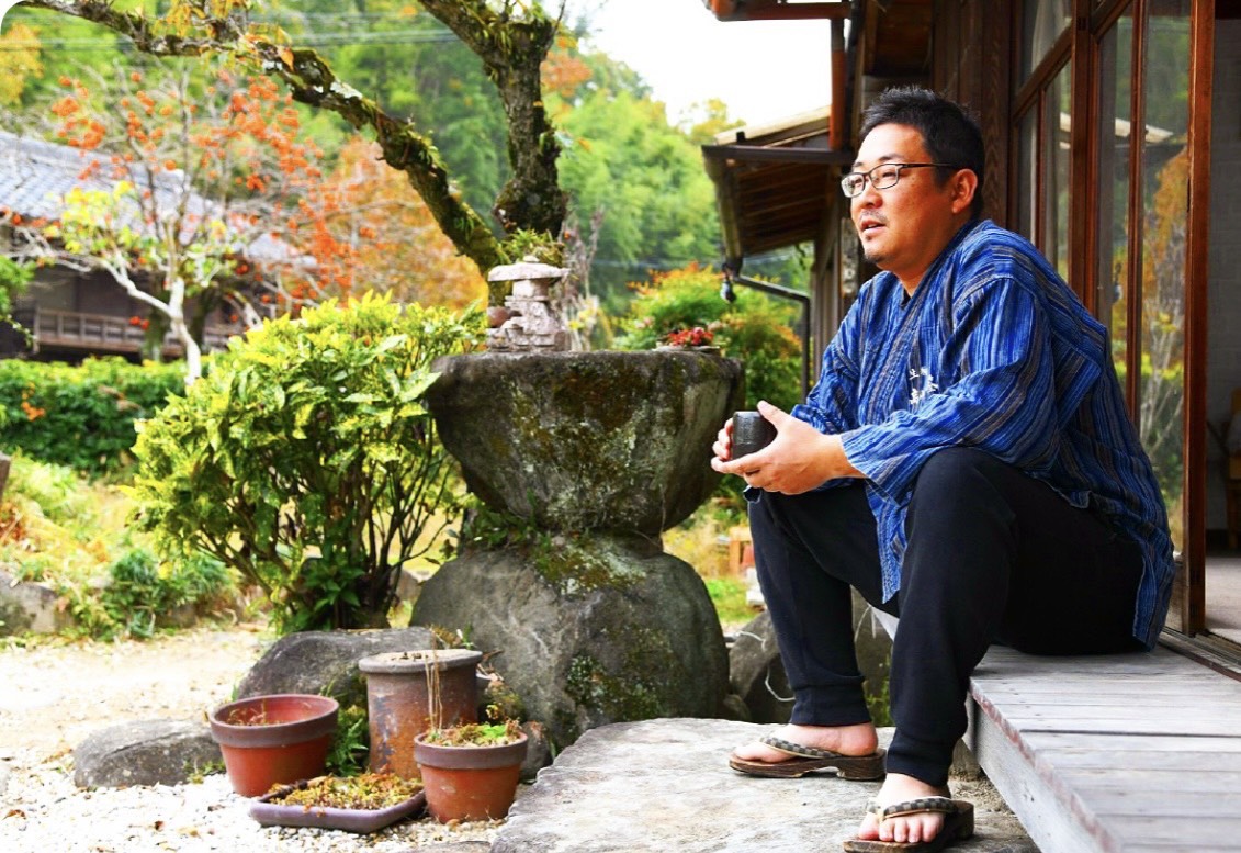 工房の縁側でお茶を手にする久保建裕